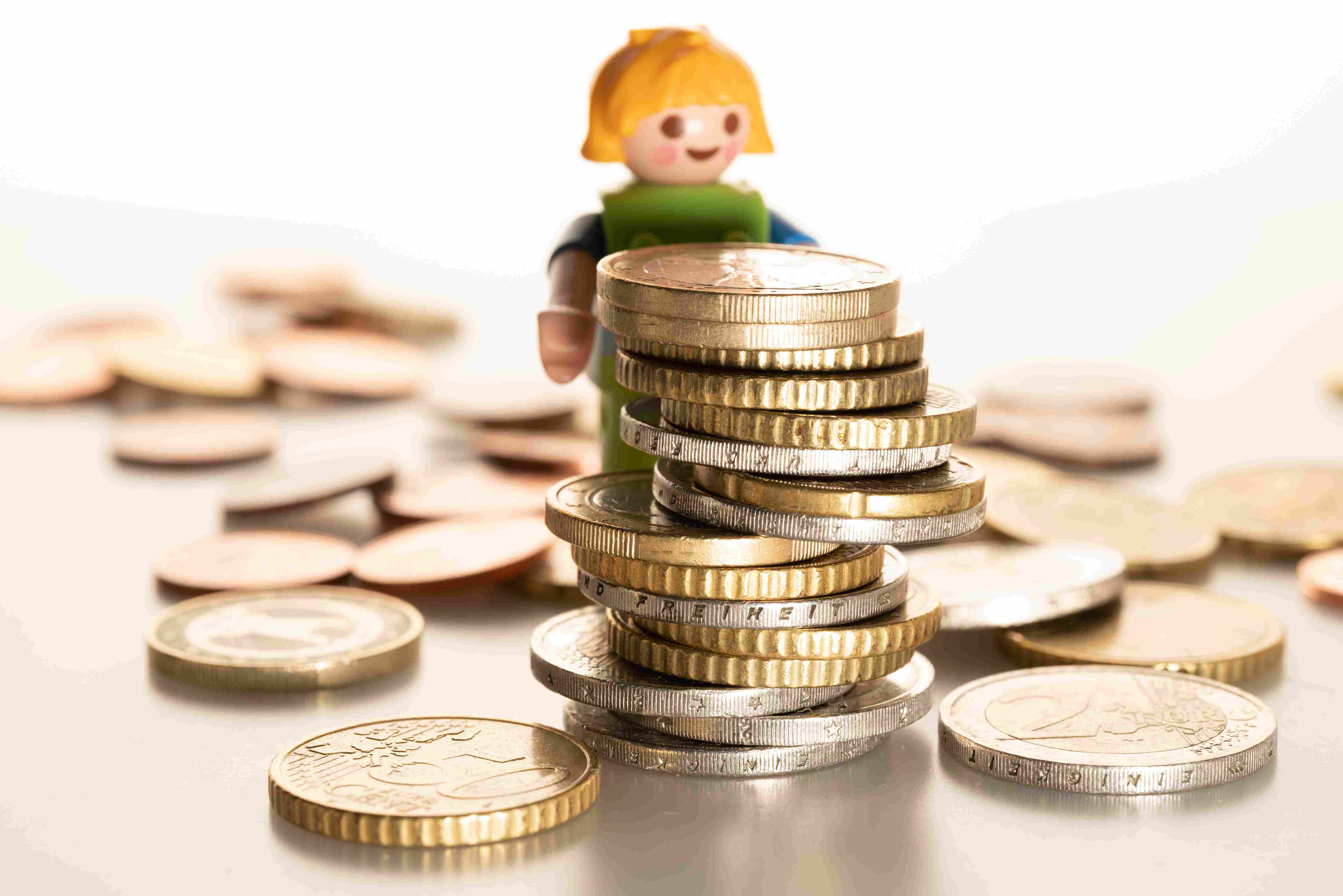 Coins infront of a figurine of a child 